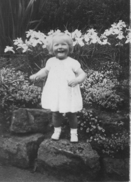 Ann b-1949 smiling in flowers.jpeg